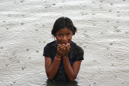 bambina gioca nel fiume